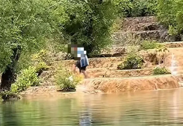 游客在四川黄龙景区钙华池内洗澡 景区：实为捡无人机